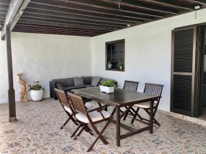 uma mesa e cadeiras numa sala de estar com um sofá em Villa Miriam em Tinajo