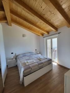 特雷梅佐的住宿－Casa del Net - Tremezzo，一间卧室设有一张大床和木制天花板。