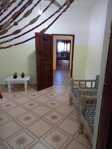 a hallway with a room with a table and chairs at Rhino Apartment Watamu in Watamu