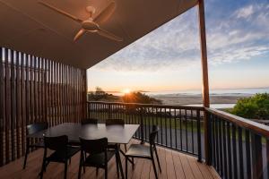 a table and chairs on a balcony with a view of the ocean at BIG4 Tasman Holiday Parks - Racecourse Beach in Bawley Point