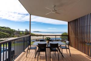 a patio with a table and chairs on a balcony at BIG4 Tasman Holiday Parks - Racecourse Beach in Bawley Point