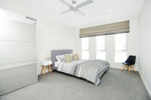 um quarto com uma cama e uma ventoinha de tecto em Executive Accommodation Absolute Beach Front em Middleton