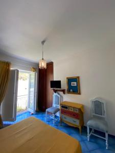 a bedroom with a bed and a desk and a tv at Lunaponzese-Ponza centro in Ponza
