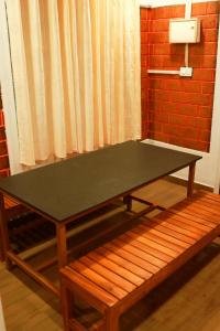 a ping pong table in a room with a bench at Water Vibes Mamalakandam in Neriyamangalam