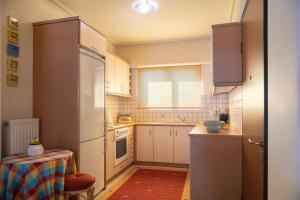 a small kitchen with white cabinets and a table in it at Lovely home apt with private parking next to Metro in Athens