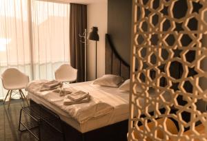 1 dormitorio con 1 cama con 2 sillas y una ventana en Hotel Arka en Orşova
