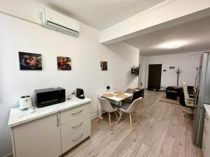 a kitchen and dining room with a table and a room at Angela Nordic apartment. in Suceava