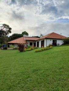 una casa con un gran campo verde delante de ella en La Estancia del Clavellino, en Los Santos