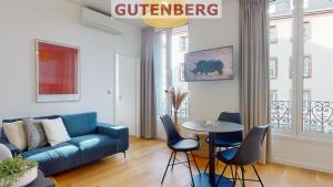 a living room with a blue couch and a table at Résidence 12 Rue de la Mesange - City Center in Strasbourg