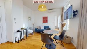 uma sala de estar com uma mesa e cadeiras e um sofá em Résidence 12 Rue de la Mesange - City Center em Estrasburgo