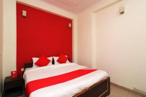 a bed with a red headboard in a room at OYO Hotel Grand Casa Near Aravali Biodiversity Park in Gurgaon