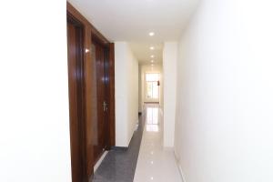 a hallway with white walls and wooden doors at OYO Hotel Dezzire in Ballabgarh