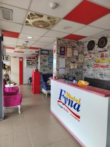 a waiting area of a restaurant with a counter and chairs at Motel Fyna in Kangar