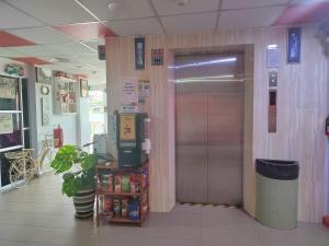 a metal elevator in a store with a door at Motel Fyna in Kangar