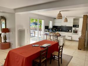a kitchen with a red table and chairs in a room at Mas provençal in Draguignan