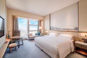 A bed or beds in a room at Four Points by Sheraton Wuhan, Jiangxia