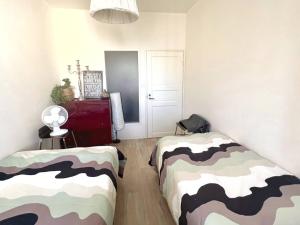 1 dormitorio con 2 camas y sábanas de camuflaje en Scandinavian Desing Home 37 City Center in Kamppi en Helsinki