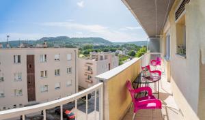 een balkon met roze stoelen en een tafel bij Apartman M in Knin