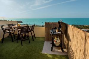 uma varanda com uma mesa e cadeiras e o oceano em Bella Paradiso em Airlie Beach