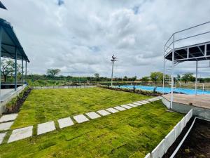 an image of a swimming pool with a grass yard at Saagvan Villa in Pune