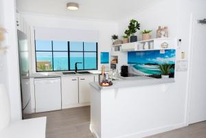 a white kitchen with a view of the ocean at Bella Paradiso in Airlie Beach