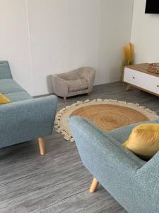 een woonkamer met 2 stoelen en een tapijt bij LOVELY PET FRIENDLY SELF CONTAINED HOLIDAY VILLA in Bongaree