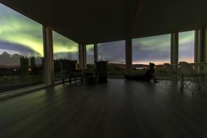 a person sitting on the floor in a room with windows at Aurora Borealis Observatory in Silsand