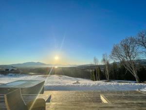 a view of the sun rising over a snow covered hill at Aurora Borealis Observatory in Silsand