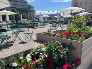 a patio with tables and chairs with flowers and umbrellas at Scandinavian Desing Home 37 City Center in Kamppi in Helsinki