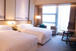 A bed or beds in a room at Four Points by Sheraton Wuhan, Jiangxia
