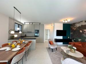 a kitchen and living room with a table and chairs at Luxury Apartment Aquamarine in Kožino +21 photos