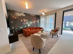a living room with a couch and two chairs at Luxury Apartment Aquamarine in Kožino