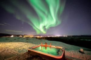 a person sitting in a bath tub under the northern lights at Aurora Borealis Observatory in Silsand