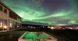 an outdoor hot tub with the aurora in the sky at Aurora Borealis Observatory in Silsand