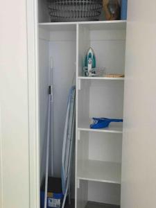 a closet with white shelves and a hose at LOVELY PET FRIENDLY SELF CONTAINED HOLIDAY VILLA in Bongaree