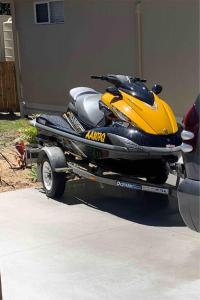 a yellow snowmobile on a trailer in a driveway at LOVELY PET FRIENDLY SELF CONTAINED HOLIDAY VILLA in Bongaree
