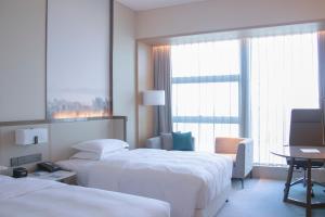 A bed or beds in a room at Four Points by Sheraton Wuhan, Jiangxia