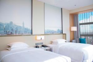 A bed or beds in a room at Four Points by Sheraton Wuhan, Jiangxia
