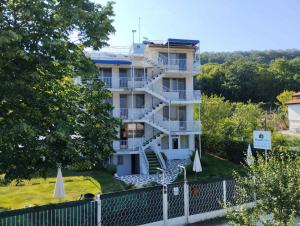 a building with a spiral staircase in front of it at Simada Blue Guesthouse in Golden Sands