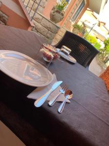 a table with plates and cutlery on a table at Villa Marogna in Alghero