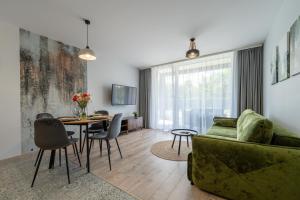 uma sala de estar com um sofá verde e uma mesa em Apartamenty Laguna Beskidów 80 i 81 Przy Jeziorze Żywieckim - Dream Apart em Zarzecze