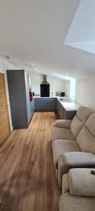 a living room with a couch and a kitchen at Town Centre Apartment in Leek