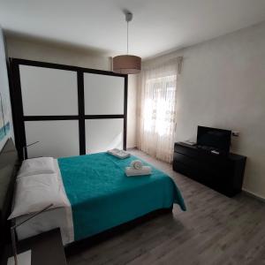 ein Schlafzimmer mit einem grünen Bett und einem TV in der Unterkunft Nettuno Bari Apartment in Bari