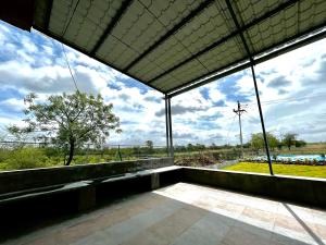 a large room with a view of a field and sky at Saagvan Villa in Pune