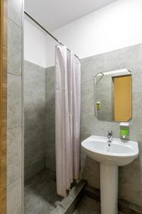 a bathroom with a sink and a mirror at Bodo Hostel in Bishkek