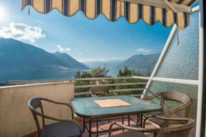 a table and chairs on a balcony with a view of the water at Majka Apartments in Kotor