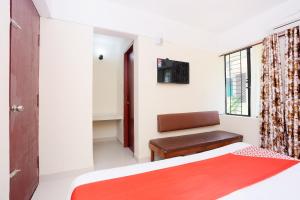 a bedroom with a bed and a chair and a window at Hotel Ganesh in Trivandrum