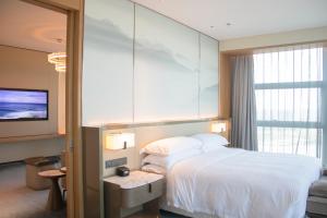 A bed or beds in a room at Four Points by Sheraton Wuhan, Jiangxia