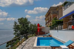 einem Pool an der Seite eines Gebäudes am Meer in der Unterkunft Pool Apartments Sweet Oasis Omiš - Happy Rentals in Lokva Rogoznica