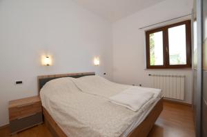 a white bedroom with a large bed and a window at Cocaletto A&B in Rovinj